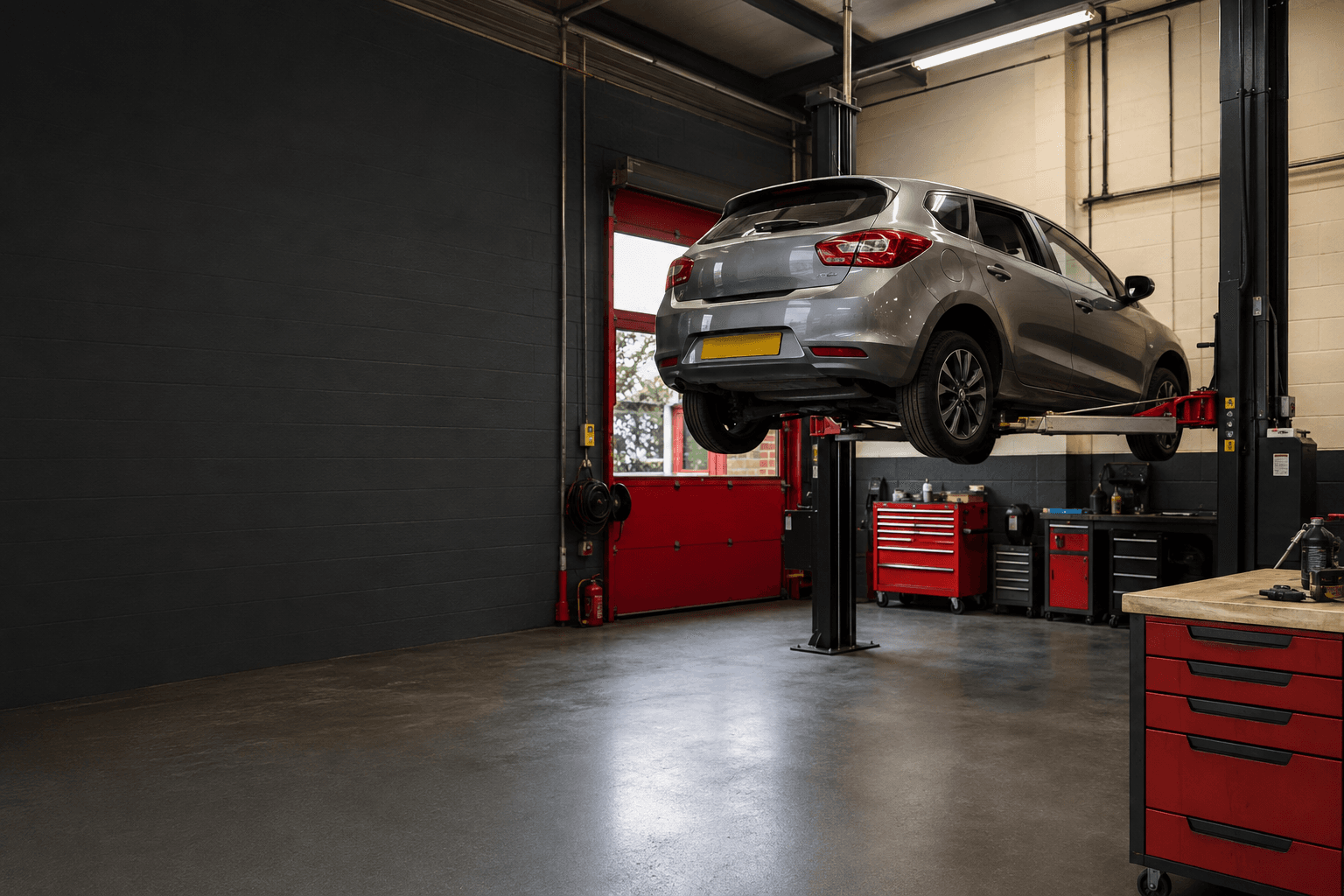 Professional independent car workshop in Gedling with red detailing and a vehicle on a lift